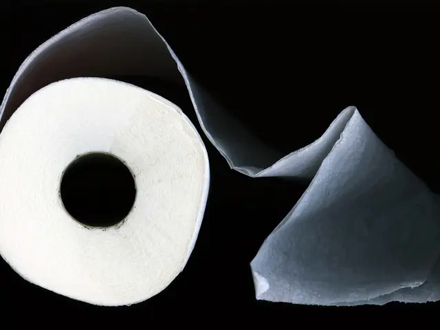 In the front of the image there is a tissue roll. In the background of the image is dark.