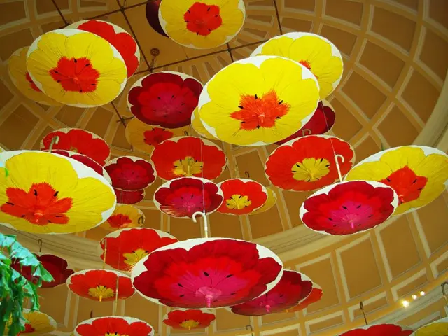 This picture consists of there are group of umbrellas hanging on the roof top, on the left side I...