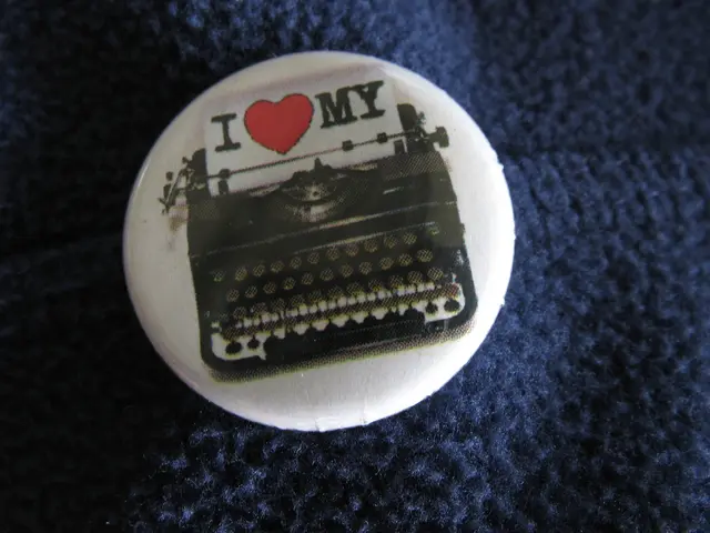 In this picture it looks like a badge with a typewriter image on it.