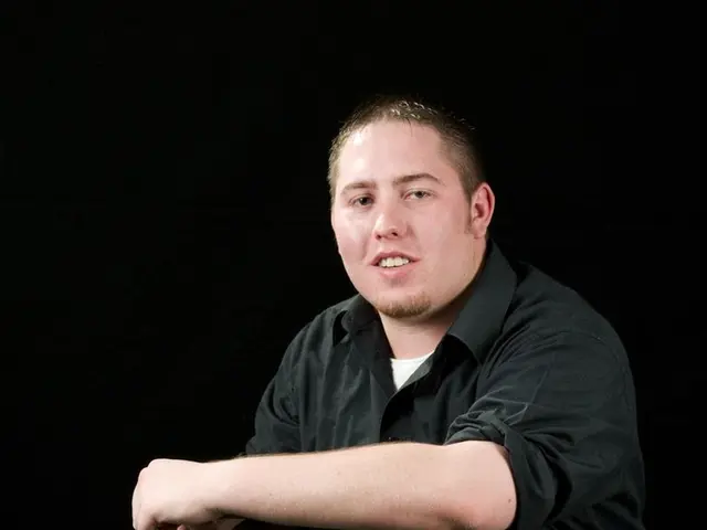 In the image we can see there is a man sitting on the chair.